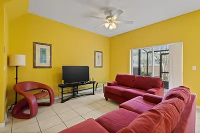 a living room with a red couch and a tv at Shvck3 - Coral Cay Resort #3 - 4 Bed 3 Baths Townhome in Kissimmee