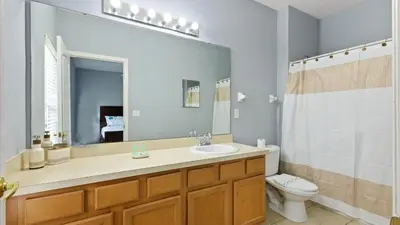 a bathroom with a sink and a toilet and a mirror at Shvck4 - Coral Cay Resort #4 - 4 Bed 3 Baths Townhome in Kissimmee