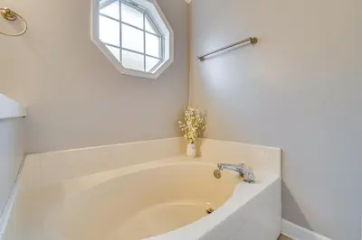 a white bath tub in a bathroom with a window at Lovely Florida Retreat with Lanai 5 Mi to Riverwalk in Lake Mary