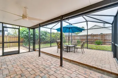 a patio with a table and an umbrella at Lovely Florida Retreat with Lanai 5 Mi to Riverwalk in Lake Mary
