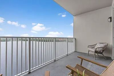 a balcony with a bench and a view of the water at Scenic View Condo Near Disney in Orlando