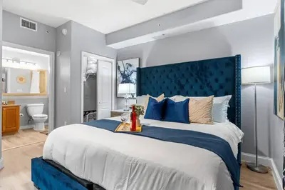 a bedroom with a large bed with a blue headboard at Scenic View Condo Near Disney in Orlando