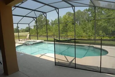 a large swimming pool with a clear enclosure at Beautiful Renovated 6 Bed Pool Home home in Kissimmee