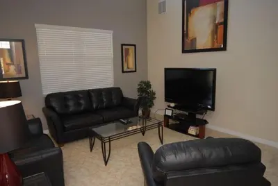 a living room with couches and a flat screen tv at Beautiful Renovated 6 Bed Pool Home home in Kissimmee