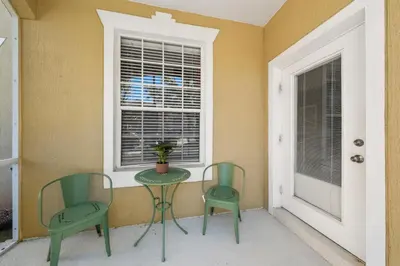 two chairs and a table in a room with a window at 2301 Butterfly Palm Way 101 in Kissimmee