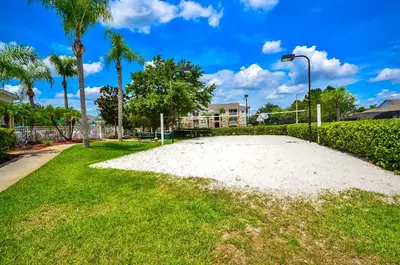 a large white beach in the grass with palm trees at 2301 Butterfly Palm Way 101 in Kissimmee