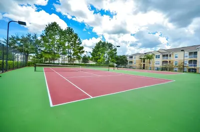 a tennis court with two people on it at 2301 Butterfly Palm Way 101 in Kissimmee