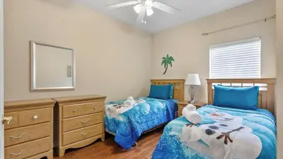 a bedroom with two beds and a dresser and a mirror at Shvck5 - Coral Cay Resort #5 - 4 Bed 3 Baths Townhome in Kissimmee