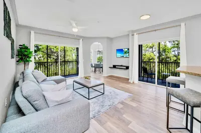 a living room with a couch and a table at Near Disney - 3BR Condo - Games Pool & Sauna in Orlando
