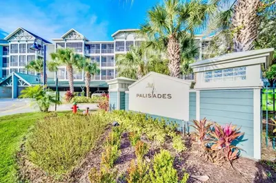 a villa with palm trees and a building at Near Disney - 3BR Condo - Games Pool & Sauna in Orlando