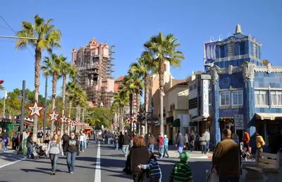 a busy city street with palm trees and people crossing the street at Near Disney - 3BR Condo - Games Pool & Sauna in Orlando