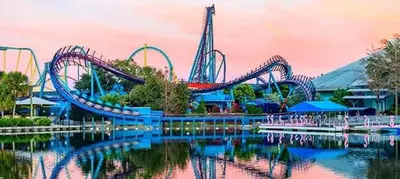 a roller coaster in a water park with its reflection in the water at Near Disney - 3BR Condo - Games Pool & Sauna in Orlando
