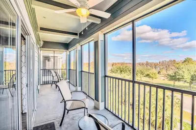 a balcony with chairs and a ceiling fan at Pet-Friendly 3BR Condo w Pool in Orlando