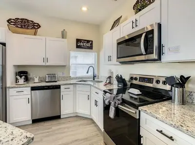 a kitchen with white cabinets and stainless steel appliances at 2025 Deals Are Here! Book Now Before Rates Go Up! in Kissimmee