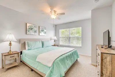 a bedroom with a bed and a flat screen tv at 11 Mi to Disney Venetian Bay Villages Townhome! in Kissimmee