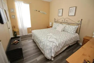a bedroom with a bed with white sheets and a window at Luxury Villa With Private Pool And Great Game Room villa in Kissimmee