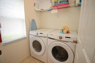 a laundry room with a washing machine and a window at Luxury Villa With Private Pool And Great Game Room villa in Kissimmee