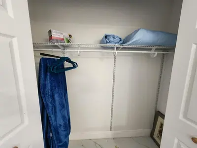 a walk in closet with a shelf and a mattress at Happy Place in Orlando