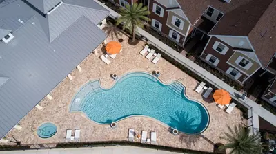 an overhead view of a swimming pool with chairs and umbrellas at 5 BR 6 BA Villa 5min to Disney! SMV154 in Orlando