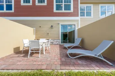 a patio with chairs and a table in front of a house at Comfortable home w 3 En-suites! SMV157 in Orlando