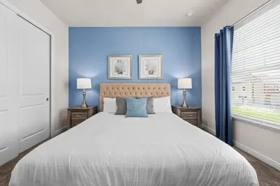 a bedroom with a large bed with a blue wall at Comfortable home w 3 En-suites! SMV157 in Orlando