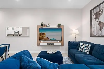 a living room with a blue couch and a tv at 4 Bedrooms 3 En-Suites, 5 Min to Disney SMV158 in Orlando