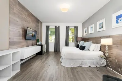 a bedroom with a white bed and wooden walls at UNIQUE MASTERPIECE15 Suites Sleeps 30 SON101 in Kissimmee