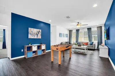 a living room with a table and a blue wall at Luxury Home at Sonoma 9 En-suites SON102 in Kissimmee