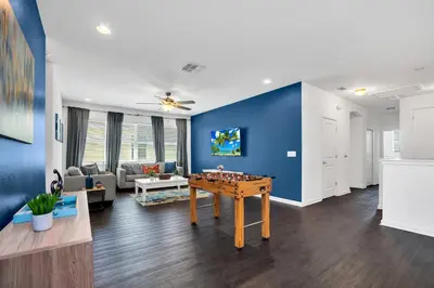 a living room with a table and a blue wall at Luxury Home at Sonoma 9 En-suites SON102 in Kissimmee