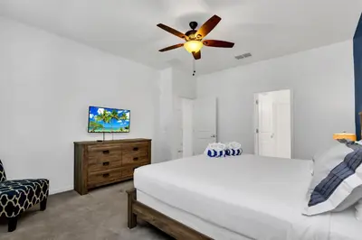 a bedroom with a white bed and a ceiling fan at Luxury Home at Sonoma 9 En-suites SON102 in Kissimmee