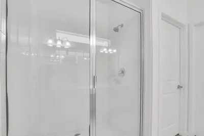 a shower with a glass door in a bathroom at Luxury Home at Sonoma 9 En-suites SON102 in Kissimmee