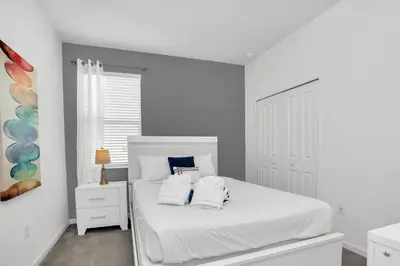 a white bedroom with a white bed with two pillows at Luxury Home at Sonoma 9 En-suites SON102 in Kissimmee