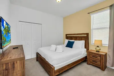 a bedroom with a large white bed and a television at Luxury Home at Sonoma 9 En-suites SON102 in Kissimmee