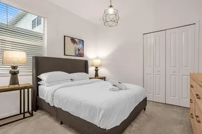 a bedroom with a bed and two lamps and a window at Luxury Villa w Pool, Home Cinema, BBQ & Near Disney Parks in Kissimmee