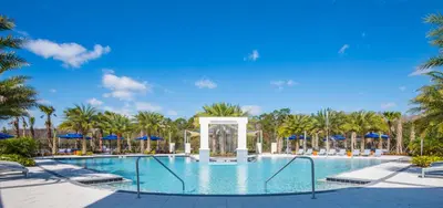 a pool at a resort with palm trees at Luxury Villa w Pool, Home Cinema, BBQ & Near Disney Parks in Kissimmee
