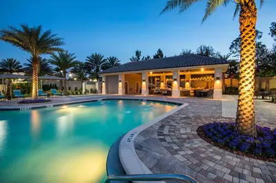 a swimming pool with a palm tree in front of a house at Luxury Villa w Pool, Home Cinema, BBQ & Near Disney Parks in Kissimmee