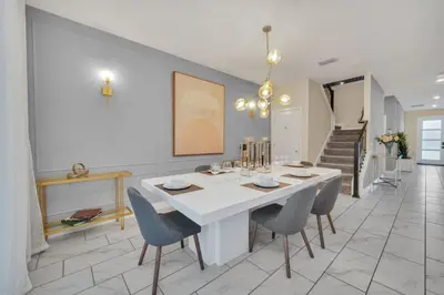 a dining room with a white table and chairs at 9 BR Family Home 8 Minutes to Disney STL119 in Kissimmee