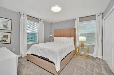 a bedroom with a bed and two windows at 9 BR Family Home 8 Minutes to Disney STL119 in Kissimmee
