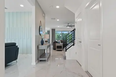 a living room with a black couch and a mirror at Stunning Modern Home VPR102 in Kissimmee