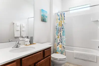 a bathroom with a sink and a toilet and a shower at Lakeview Home Sleeps 25 VPR103 in Kissimmee