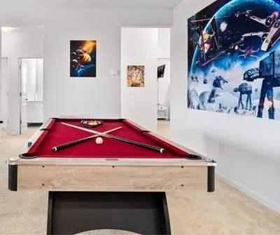 a pool table in a living room with avertisement for at Lakeview Home Sleeps 25 VPR103 in Kissimmee