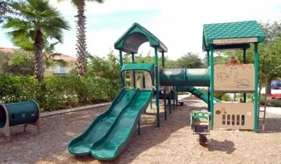a playground with a green slide in a park at A Peaceful Orlando Escape, nature, comfort & Disney Nearby EMI101 in Kissimmee