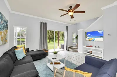 a living room with a couch and a ceiling fan at A Peaceful Orlando Escape, nature, comfort & Disney Nearby EMI101 in Kissimmee