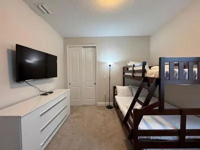 a bedroom with a bunk bed and a flat screen tv at 7491 Oasis at Reunion sleeps 12 in Orlando