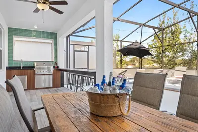 a kitchen and dining room with a wooden table and chairs at Unique Masterpiece 15 En-suites VPR104 in Kissimmee