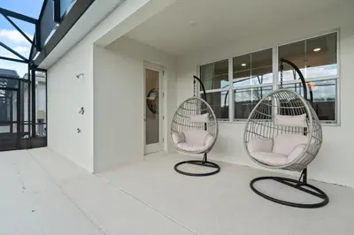 two chairs sitting on a porch in front of a building at Brand New Masterpiece 15 En-Suites SON105 in Kissimmee