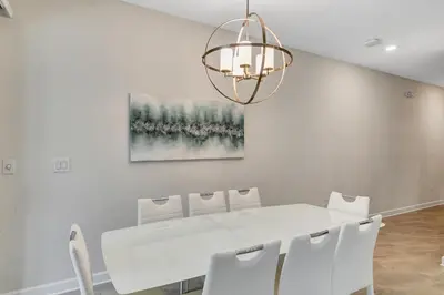 a dining room with a white table and a chandelier at Private Pool 8 Min to Disney STL121 in Kissimmee