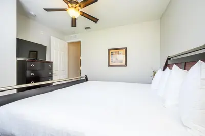 a bedroom with a bed and a ceiling fan at Epic Universe Premium Lake View Condo, Vista Cay - 1002 in Orlando