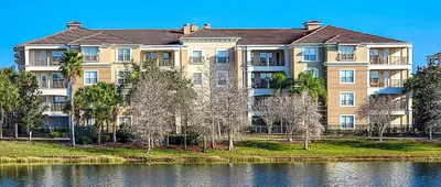 a large apartment building next to a body of water at Gorgeous 3 Bed Lakeview, Vista Cay - 1010 in Orlando