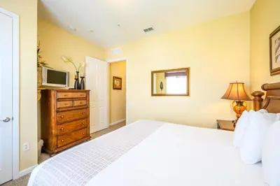 a bedroom with a white bed and a television at Tropical Lakeview Condo W Vegas Game Room - 1014 in Orlando